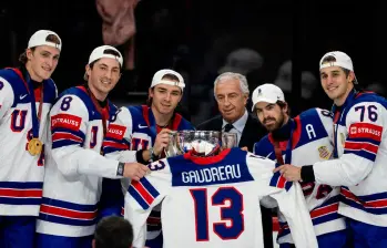Los deportistas de la Selección de Estados Unidos de hockey sobre hielo celebran con la camiseta de Gaudreau el trofeo de las olimpiadas. FOTO: AFP