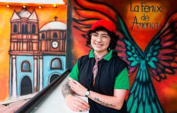 Daniela posa frente a uno de los murales que ha hecho en El Peñol. Su trabajo hace énfasis en la historia del municipio. FOTO Manuel Saldarriaga