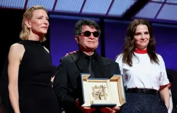 El director iraní Jafar Panahi entre Cate Blanchett y Juliette Binoche, en el Festival de Cannes el 24 de mayo de 2025. FOTO: AFP
