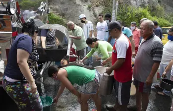Imagen de referencia de un carrotanque surtiendo de agua a una comunidad de Medellín. Foto EL COLOMBIANO