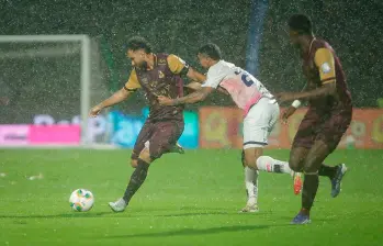 Juan Pablo Nieto protege en balón en un campo difícil por la lluvia en Bogotá. FOTO COLPRENSA