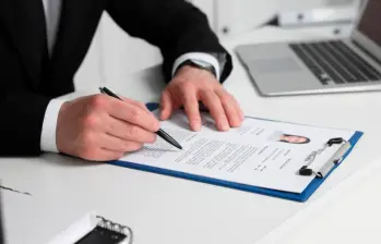 Headhunter explicándole a un candidato qué habilidades se deben resaltar en una hoja de vida para una búsqueda efectiva de empleo. FOTO: iStock