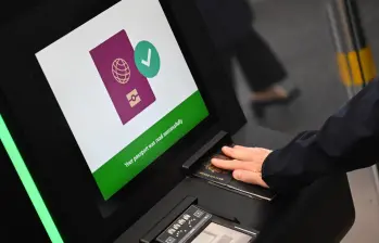 Una persona escaneando su pasaporte en una máquina. FOTO: AFP