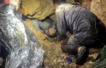 Esta es una captura de pantalla tomada de un video facilitado el 29 de mayo de 2026 por Metta Tham Rescue Kalasin y muestra a un equipo de rescate liberando a uno de los siete hombres (izquierda) atrapados en una cueva semisumergida en la provincia central de Xaysomboun, al noreste de la capital, Vientiane. Foto: AFP