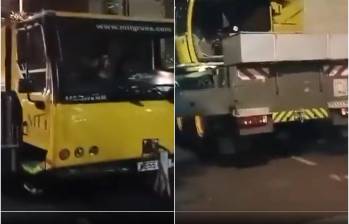 La grúa de color amarillo se encontraba bloqueando la vía pública sin permiso y poniendo en riesgo a los transeúntes por subir un carro BMW a un edificio. FOTO: CAPTURA VIDEO REDES SOCIALES 