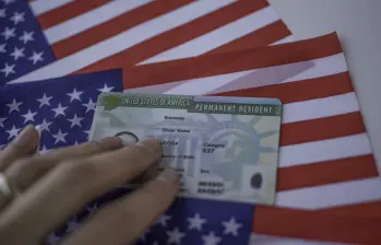 Permanent Resident Green card of United states of America on flag of USA. Above close up view.