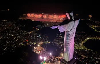 Un espectáculo de luces se proyecta sobre el Arco de Triunfo mientras los fuegos artificiales iluminan el cielo durante las celebraciones de Año Nuevo en los Campos Elíseos de París (Francia). Foto: Afp 