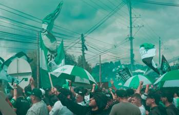 Los aficionados del cuadro verde se instalaron sobre la autopista Medellín-Bogotá, para cantarle a sus jugadores en la sede de Guarne. Foto: tomada del x de @nacionaloficial