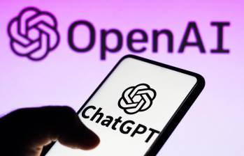 En primer plano, un celular con la aplicación de ChatGPT. Al fondo, la empresa OpenAI, los dueños de la IA mencionada. FOTO: DEPOSITPHOTOS