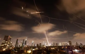 Imagen que muestra la entrada y salida de misiles en Tel Aviv, Israel, tras recibir los ataques de respuesta por parte de Irán, durante una noche en los últimos cinco días de guerra. FOTO: AFP