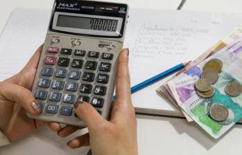 Persona con calculadora en mano haciendo la cuenta de cuánto le deberán pagar por su recargos dominicales. FOTO: EL COLOMBIANO