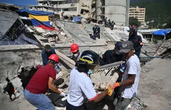 Las autoridades venezolanas continúan las labores de búsqueda y remoción de escombros tras los terremotos que dejaron miles de muertos en el estado La Guaira. FOTO: AFP. 