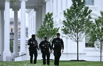 Agentes del Servicio Secreto acordonan el perímetro de la Casa Blanca, tras el reporte de entre 20 y 25 disparos cerca del edificio presidencial, donde el presidente Donald Trump se encontraba en ese momento. FOTO AFP