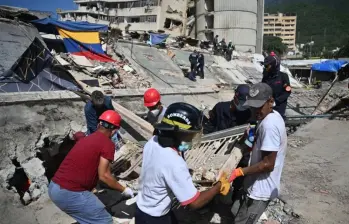Las autoridades venezolanas continúan las labores de búsqueda y remoción de escombros tras los terremotos que dejaron miles de muertos en el estado La Guaira. FOTO: AFP.