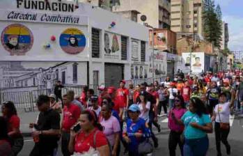 Los partidarios del presidente Nicolás Maduro pasan por la sede de la ‘Catedral Combativa’, un grupo progubernamental conocido como ‘Colectivos’, en el centro de Caracas el 5 de enero de 2025. ‘Somos los defensores de la patria, los defensores de la revolución proceso”, proclama Teodoro Cortez, segundo al mando del ‘Colectivo Catedral’, que responde a las críticas contra estos grupos calificados por la oposición y activistas de derechos humanos como ‘paramilitares’ en el servicio del gobierno. (Foto de Gabriela ORAA/AFP)