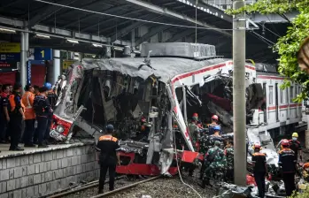 Equipos de rescate y trabajadores inspeccionan los restos de los trenes involucrados en el choque ocurrido en la estación Bekasi Timur, en las afueras de Yakarta, Indonesia. FOTO: AFP. 