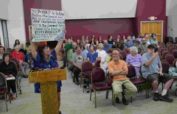 Una señora sosteniendo una pancarta en contra. FOTO: AFP