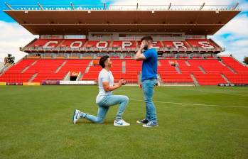 Josh Cavallo, de rodillas, le pide matrimonio a su pareja Leighton Morrell, en el estadio Hindmarsh. FOTO: Tomada de Instagram @joshua.cavallo