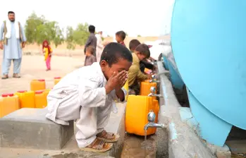 Niños afganos recogen agua de un camión cisterna en Kabul, donde el acceso al líquido vital es cada vez más limitado. CRÉDITO: UN- HABITAT AFGHANISTAN
