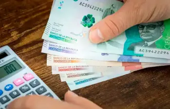 Persona realizando una operación matemática en su calculadora para determinar de cuánto será el pago de su liquidación. FOTO: Shutterstock