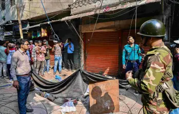 Un miembro del ejército resguarda la zona tras el colapso parcial de un edificio en Old Dhaka, luego del fuerte sismo que dejó al menos tres muertos y varios heridos. FOTO: AFP.
