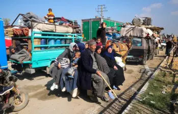 Azotados por la guerra, los desplazados de Gaza viajan en la parte trasera de un carro tirado por caballos mientras cruzan el corredor de Netzarim desde el sur de la Franja de Gaza hacia la parte norte. FOTO: AFP