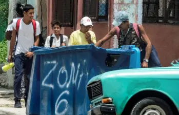 Un hombre hurga en un contenedor de basura en La Habana. La mendicidad en Cuba está asociada a la pobreza extrema, el abandono familiar y problemas de salud mental. FOTO: AFP