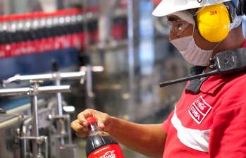 Empleado de Coca Cola FEMSA revisando una botella en una planta de producción. FOTO: Cortesía