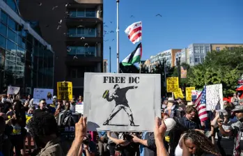 Una persona sostiene un cartel durante una manifestación contra el despliegue de la Guardia Nacional y el aumento de las redadas de inmigración en Washington. FOTO: AFP