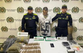 El capturado en Barrio Antioquia junto con la marihuana que fue incautada en la propiedad que servía como acopio ilegal. FOTO Policía Metropolitana. 