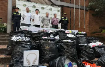 En las bolsas negras, todos los celulares y artículos recuperados e incautados. Al fondo, los cuatro capturados en el Opera. FOTO Policía Metropolitana. 