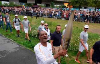 El rapero estadounidense Snoop Dogg con la llama olímpica afuera del estadio Olímpico de Francia. FOTO: GETTY