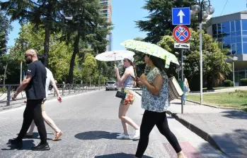 Las personas van con sombrillas debido al intenso calor. FOTO: AFP
