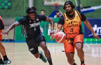 Emanuel Payton, de Toros del Valle, trata de contener a Mike Miles, de Paisas (naranja), en el duelo disputado en el Iván de Bedout. FOTO Manuel Saldarriaga 