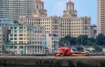 Un hombre duerme en el Malecón de La Habana. Los niveles de pobreza han aumentado drásticamente mientras Cuba enfrenta su peor crisis económica en tres décadas, caracterizada por una grave escasez de alimentos, medicinas y combustible, además de apagones diarios. Foto: AFP