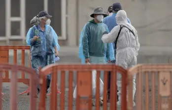Con trajes de protección, desinfecciones constantes, separadores con pantallas profilácticas y otras seguridades, se ha realizado el desembarco y traslado de los pasajeros del crucero. Foto: Jorge Guerrero / AFP
