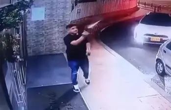 El hombre fue grabado realizando al menos 12 disparos al aire en la entrada de un conjunto residencial en el norte de Bogotá. FOTO: captura de video. 