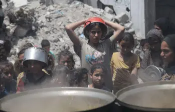Palestinos esperan para recibir alimentos en un campamento de refugiados de Jabalia, en el norte de la Franja de Gaza, el 19 de mayo de 2025. Israel permitió entrada de suplementos humanitarios después de mantener el bloqueo en el territorio palestino desde el 2 de marzo. FOTO: Xinhua