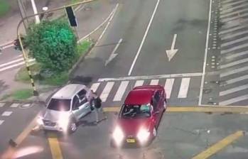 La pareja del vehículo rojo enfrentó con un arma al conductor que chocó con otro carro en la avenida El Poblado. FOTO: CAPTURA DE PANTALLA