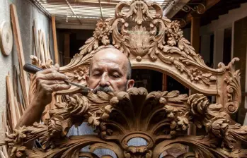 El maestro Sigifredo Cardona repasa los acabados de la talla hecha en una obra. FOTO Julio Herrera