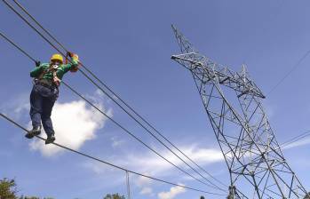 Una obrera realiza labores de mantenimiento a una línea de energía. Foto: Esneyder Gutiérrez