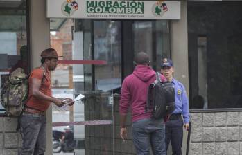 Imagen de referencia de unos migrantes realizando trámites en una oficina de Migración Colombia en Medellín. Foto: Julio César Herrera Echeverri