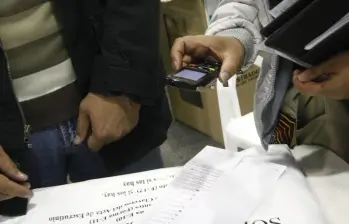 Una testigo electoral toma una fotografía del Formulario E-14 con su celular. Foto: Colprensa - Christian Castillo