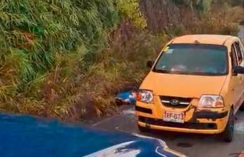 Las dos personas que iban en este taxi fueron acribilladas afuera del automotor, luego de que estructuras armadas lo interceptaran poniendo un árbol en el centro de la vía. IMAGEN TOMADA DE VIDEO.