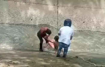 La comunidad participó en el rescate de la mujer quemada dentro de un cambuche en el Barrio Antioquia de la corriente de la quebrada La Guayabala, para luego trasladarla a la Cruz Roja. FOTO: Cortesía