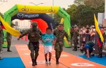 Este es el momento en el que los soldados ayudan al niño de 10 años, a cruzar la meta en la Maratón del Valle. FOTO PANTALLAZO 