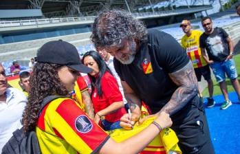 El técnico Leonel Álvarez firmándole una camiseta a una hincha del Pereira. FOTO: CUENTA DE X @DeporPereiraFC