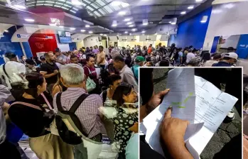 Adelante, una usuaria muestra su autorización de medicinas ad portas de vencerse por falta de entrega de medicamentos. Atrás, usuarios de la Nueva EPS en su sede de la Avenida ORiental. FOTO: Julio Herrera