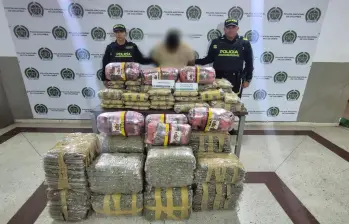 El hombre junto con la droga incautada por la Policía. FOTO: Cortesía