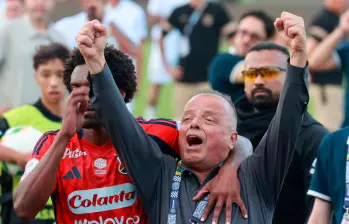 Este es el momento en el que Didier Moreno trata de sacar del campo a Raúl Giraldo, máximo accionista del DIM, quien se enfrentó a los hinchas Poderosos que terminaron molestos por la eliminación. FOTO: MANUEL SALDARRIAGA. 